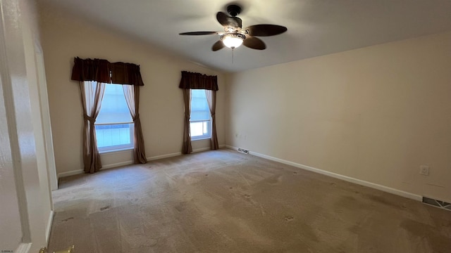 spare room with lofted ceiling, light colored carpet, and ceiling fan