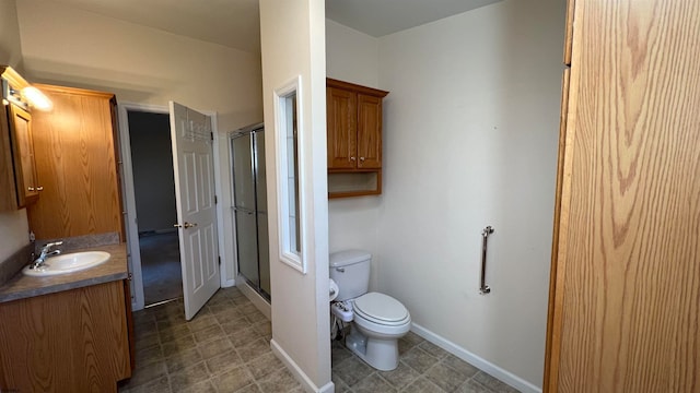 bathroom featuring a shower with door, vanity, and toilet