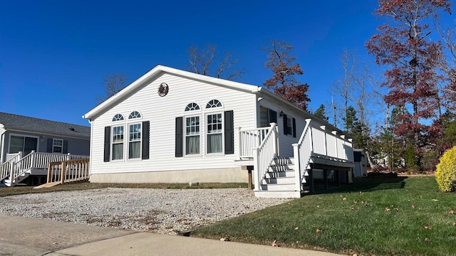 view of front of house featuring a front lawn and a deck