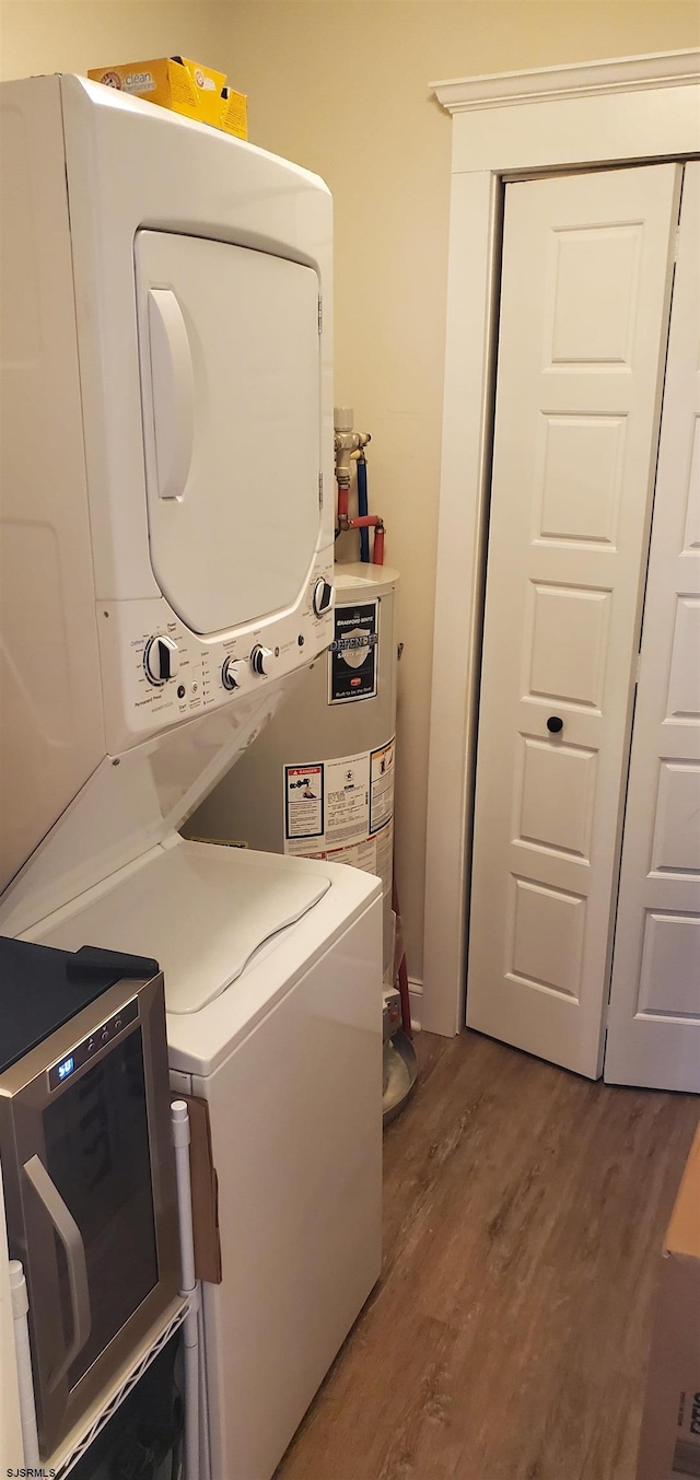 washroom featuring hardwood / wood-style floors and stacked washer / drying machine