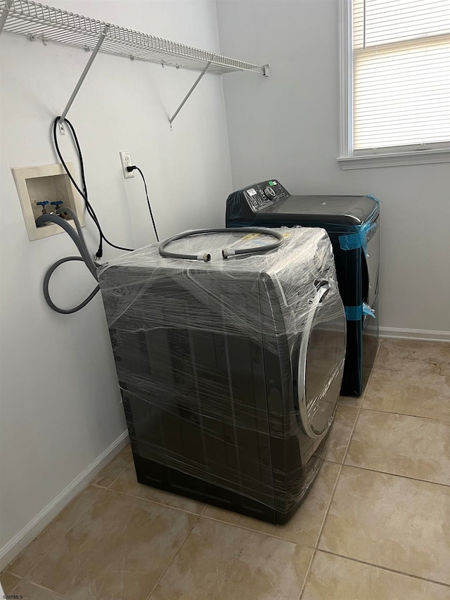 washroom featuring separate washer and dryer and light tile patterned floors