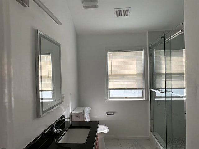 bathroom with walk in shower, vanity, and toilet