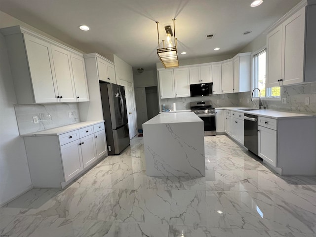 kitchen with white cabinetry, sink, appliances with stainless steel finishes, a kitchen island, and pendant lighting