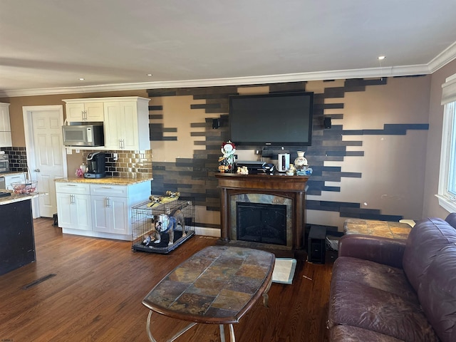 living room featuring dark wood-type flooring and ornamental molding