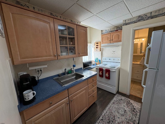 kitchen featuring dark wood-type flooring, a paneled ceiling, white appliances, and sink