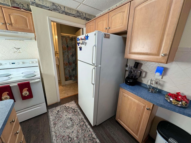 kitchen featuring white appliances, backsplash, dark hardwood / wood-style flooring, and a drop ceiling