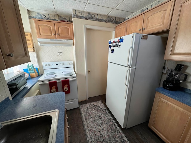 kitchen featuring white appliances, dark hardwood / wood-style floors, a paneled ceiling, and decorative backsplash