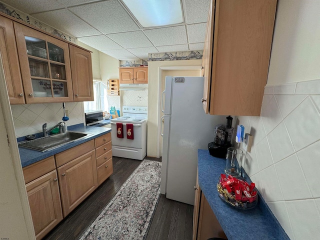 kitchen featuring white appliances, sink, dark hardwood / wood-style flooring, and a drop ceiling