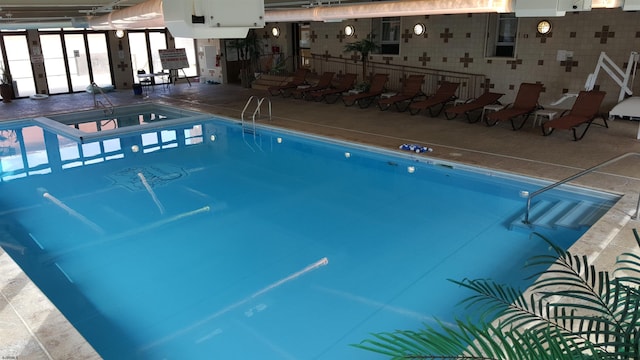 view of pool featuring a hot tub and a patio area