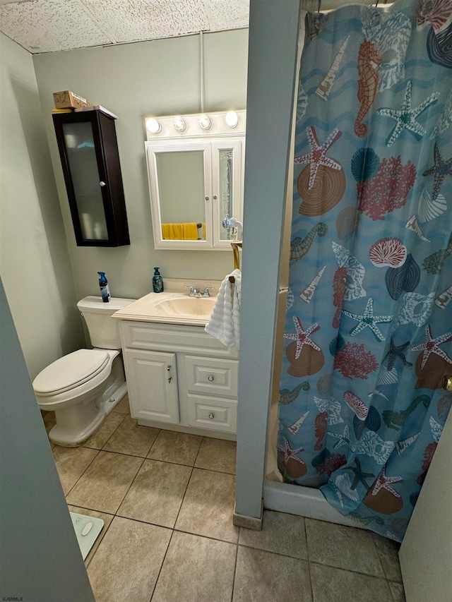 bathroom with tile patterned flooring, curtained shower, vanity, and toilet