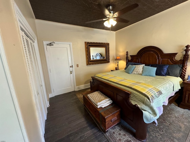 bedroom with dark hardwood / wood-style floors, ceiling fan, and a closet