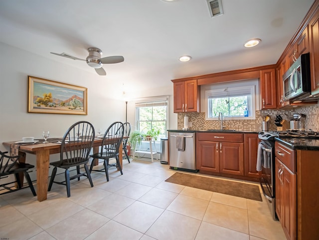 kitchen with sink, light tile patterned floors, ceiling fan, backsplash, and appliances with stainless steel finishes