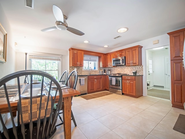 kitchen with stainless steel appliances, sink, tasteful backsplash, ceiling fan, and light tile patterned floors