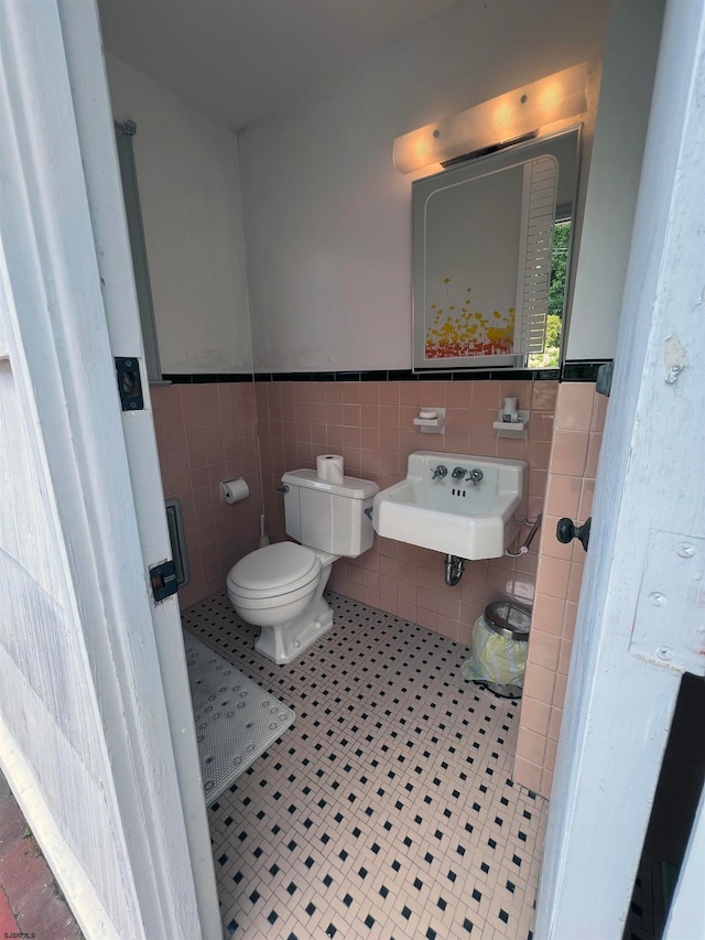 bathroom featuring tile walls, tile patterned flooring, sink, and toilet