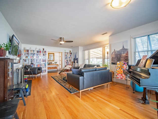 living room featuring wood-type flooring and ceiling fan