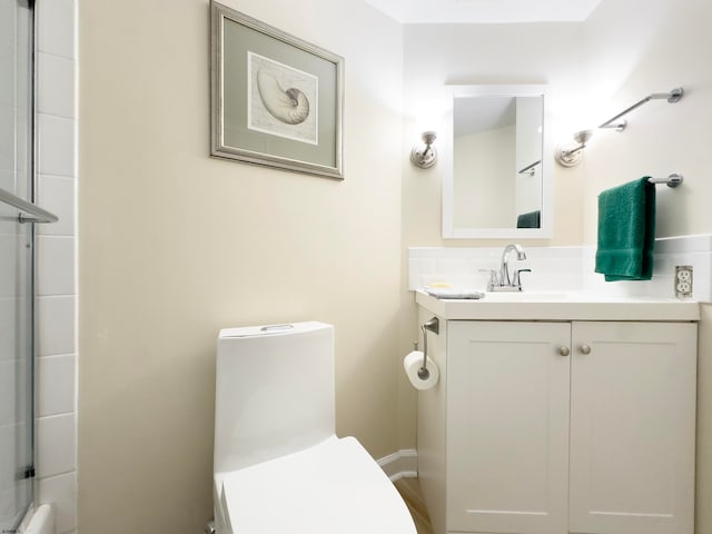 bathroom featuring walk in shower, vanity, and toilet