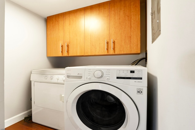 laundry area featuring wood-type flooring, cabinets, and independent washer and dryer