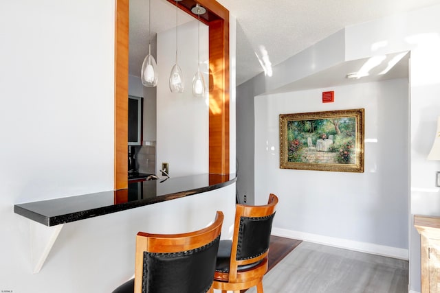 dining area featuring a textured ceiling and dark hardwood / wood-style flooring