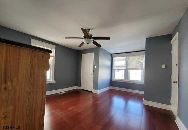 interior space with ceiling fan and dark hardwood / wood-style flooring