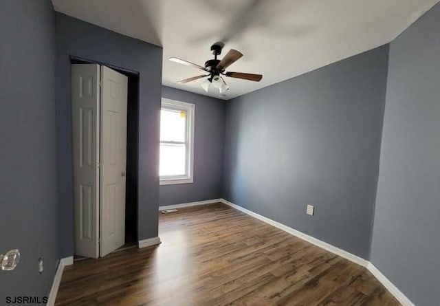 empty room featuring ceiling fan and dark hardwood / wood-style floors