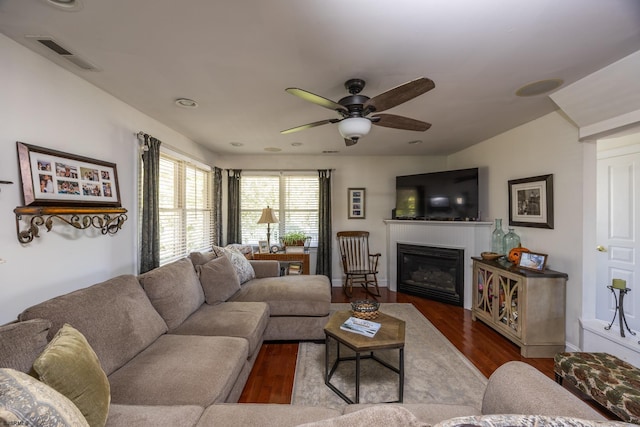 living room featuring ceiling fan and dark hardwood / wood-style floors