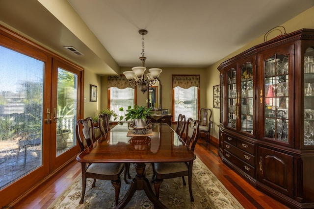 dining area featuring a notable chandelier, dark hardwood / wood-style floors, and plenty of natural light