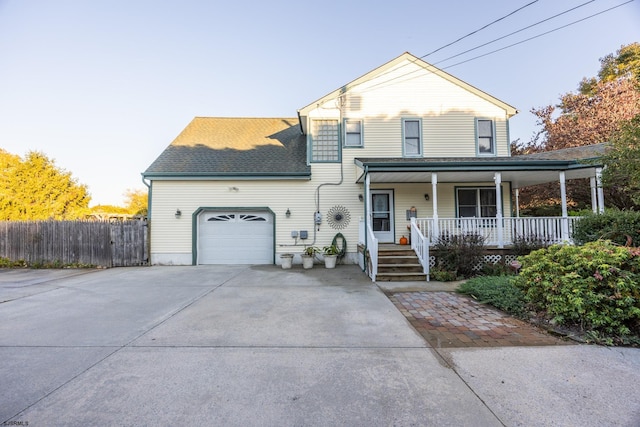 view of property with a porch and a garage