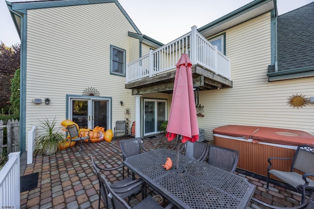 exterior space with a patio, a balcony, and a hot tub