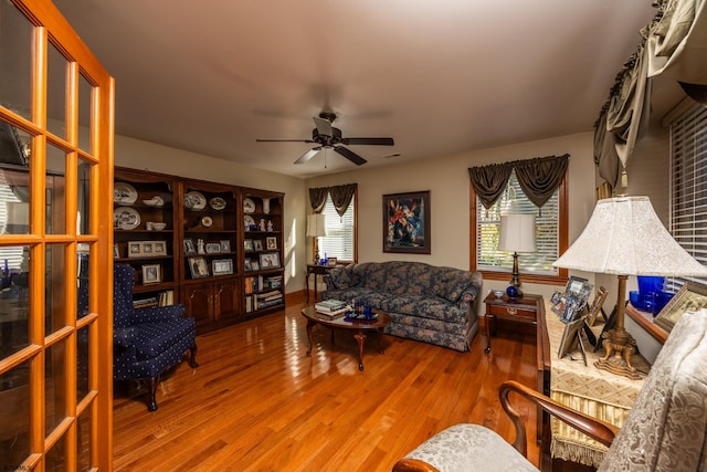 living room featuring ceiling fan, hardwood / wood-style floors, and plenty of natural light