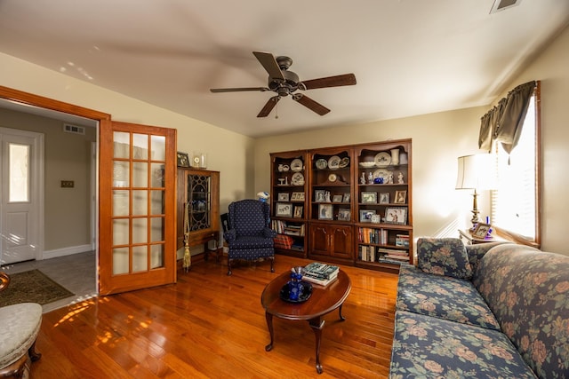 living room with wood-type flooring, vaulted ceiling, and ceiling fan