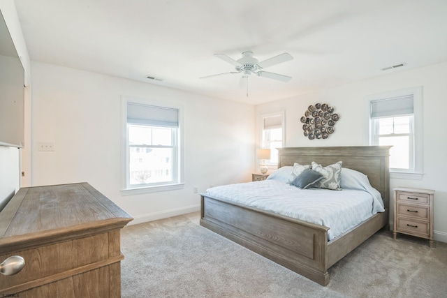 carpeted bedroom with ceiling fan and multiple windows