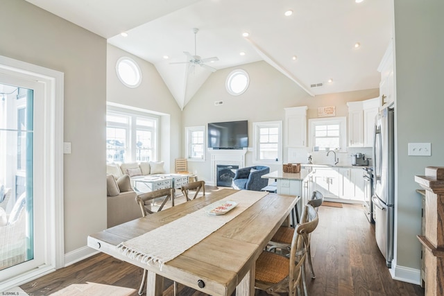 dining area with high vaulted ceiling, dark hardwood / wood-style floors, ceiling fan, and sink