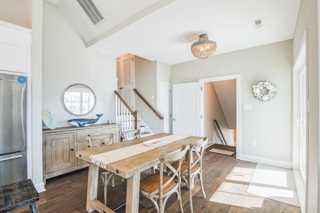 dining space with dark hardwood / wood-style flooring and vaulted ceiling