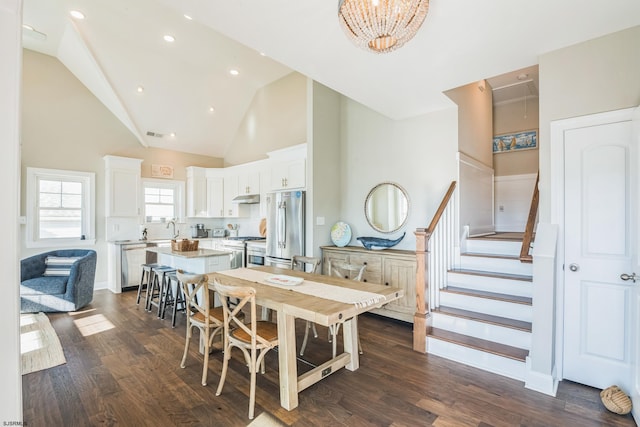 dining space with high vaulted ceiling, dark hardwood / wood-style floors, a chandelier, and sink