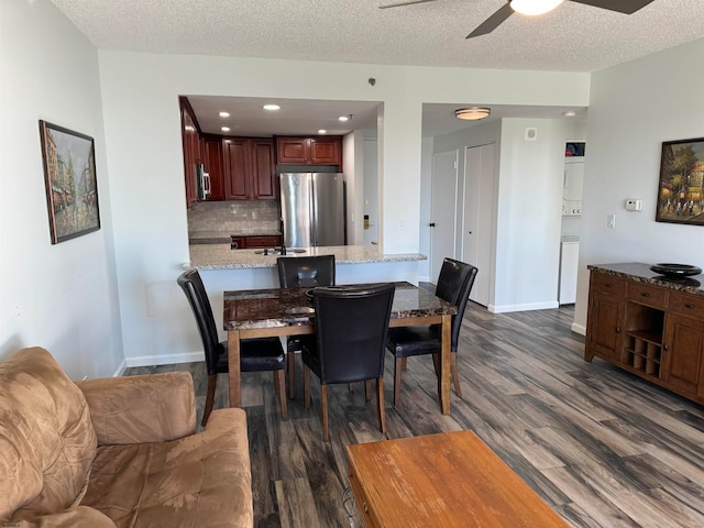 dining area with ceiling fan, a textured ceiling, and dark hardwood / wood-style flooring