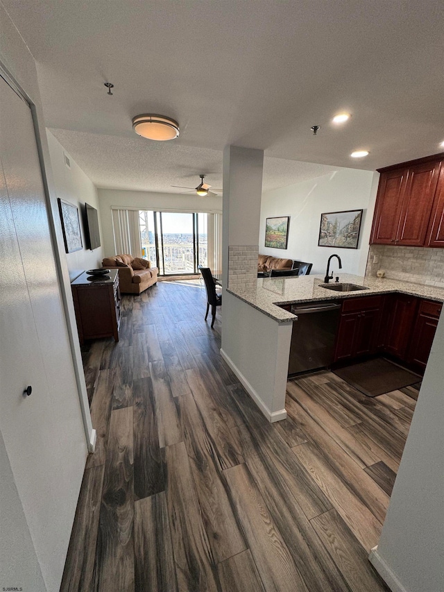 kitchen featuring dark wood-type flooring, stainless steel dishwasher, kitchen peninsula, and sink