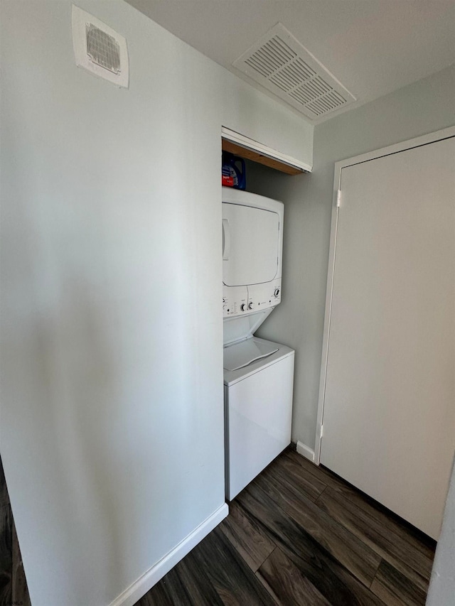 washroom with stacked washer and dryer and dark hardwood / wood-style floors