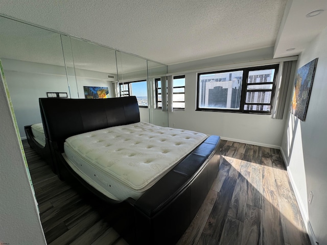 bedroom featuring dark wood-type flooring and a textured ceiling