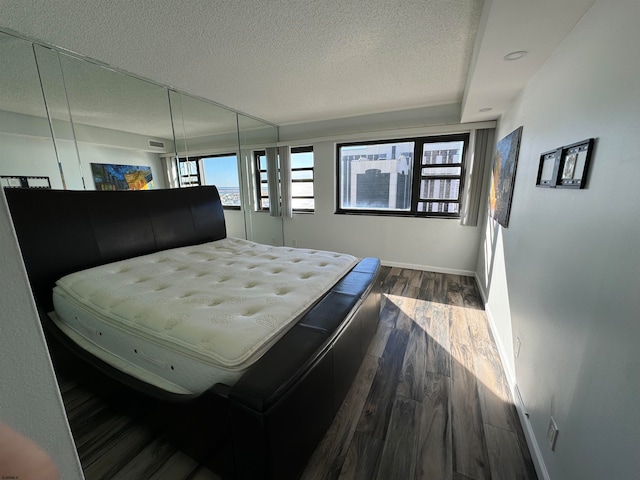 bedroom featuring dark hardwood / wood-style floors and a textured ceiling