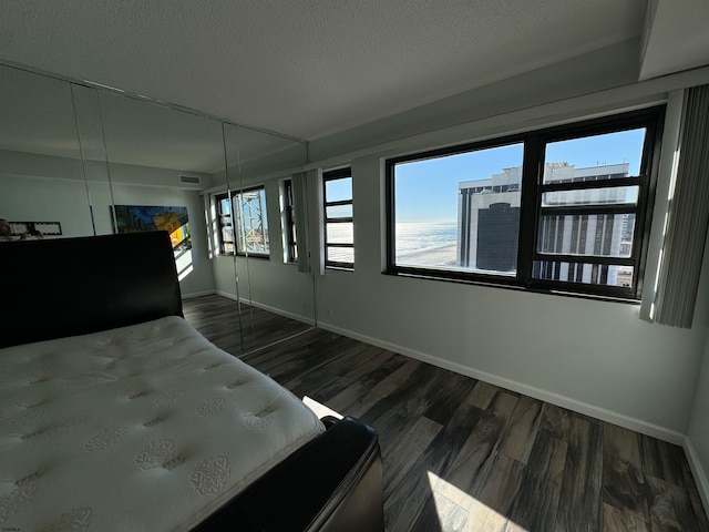 unfurnished bedroom featuring dark wood-type flooring and a textured ceiling