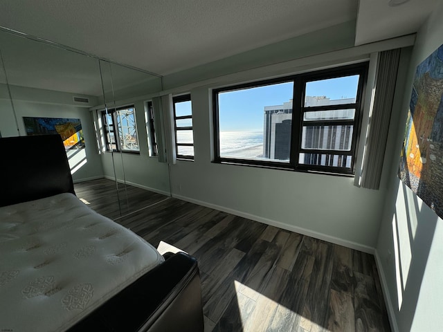 unfurnished bedroom featuring dark hardwood / wood-style flooring and a textured ceiling