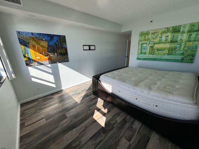 bedroom featuring wood-type flooring and a textured ceiling