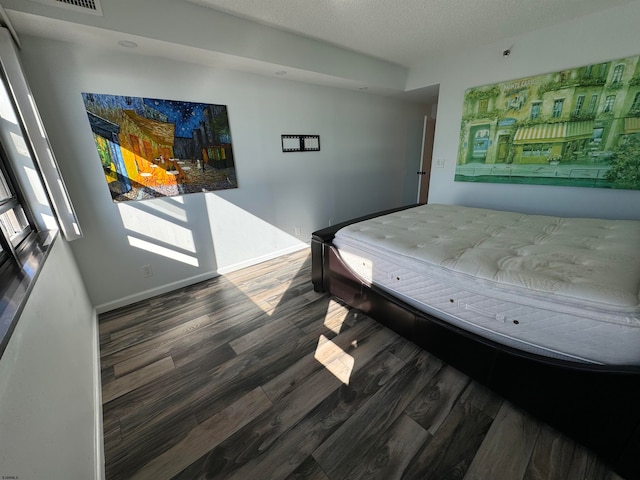 bedroom featuring a textured ceiling and hardwood / wood-style flooring