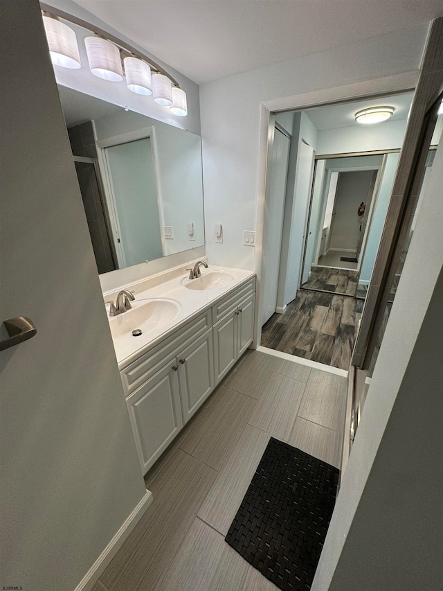 bathroom featuring hardwood / wood-style floors, walk in shower, and vanity