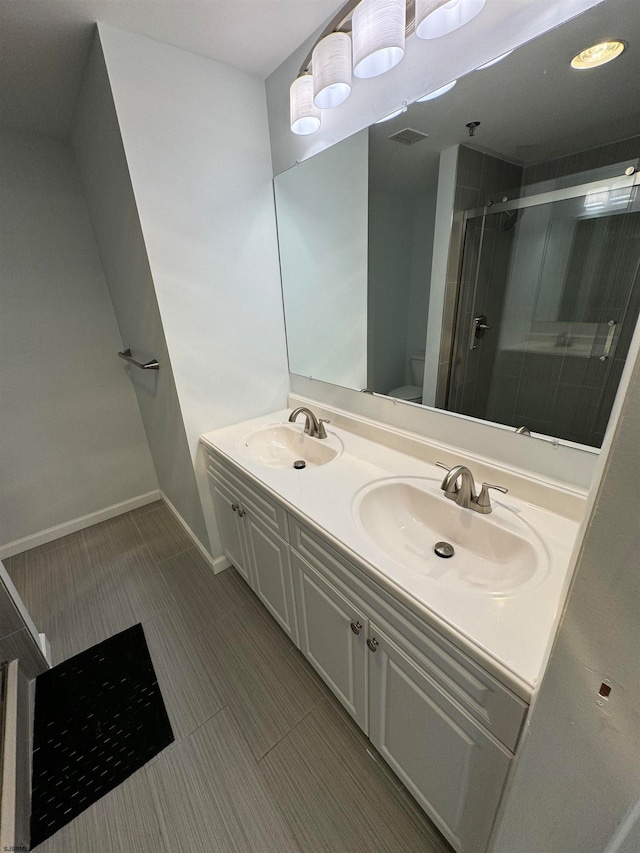 bathroom with toilet, vanity, and an enclosed shower