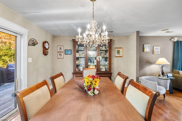 dining space featuring light hardwood / wood-style floors and a chandelier