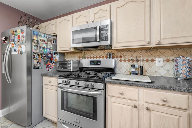 kitchen featuring backsplash, light brown cabinets, light tile patterned floors, and stainless steel appliances