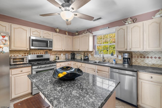 kitchen with a kitchen island, appliances with stainless steel finishes, sink, and tasteful backsplash