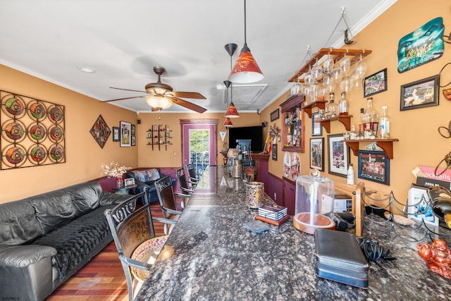 living room featuring hardwood / wood-style flooring, ceiling fan, and ornamental molding