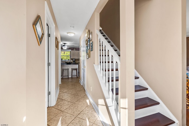 stairway with tile patterned floors and ceiling fan